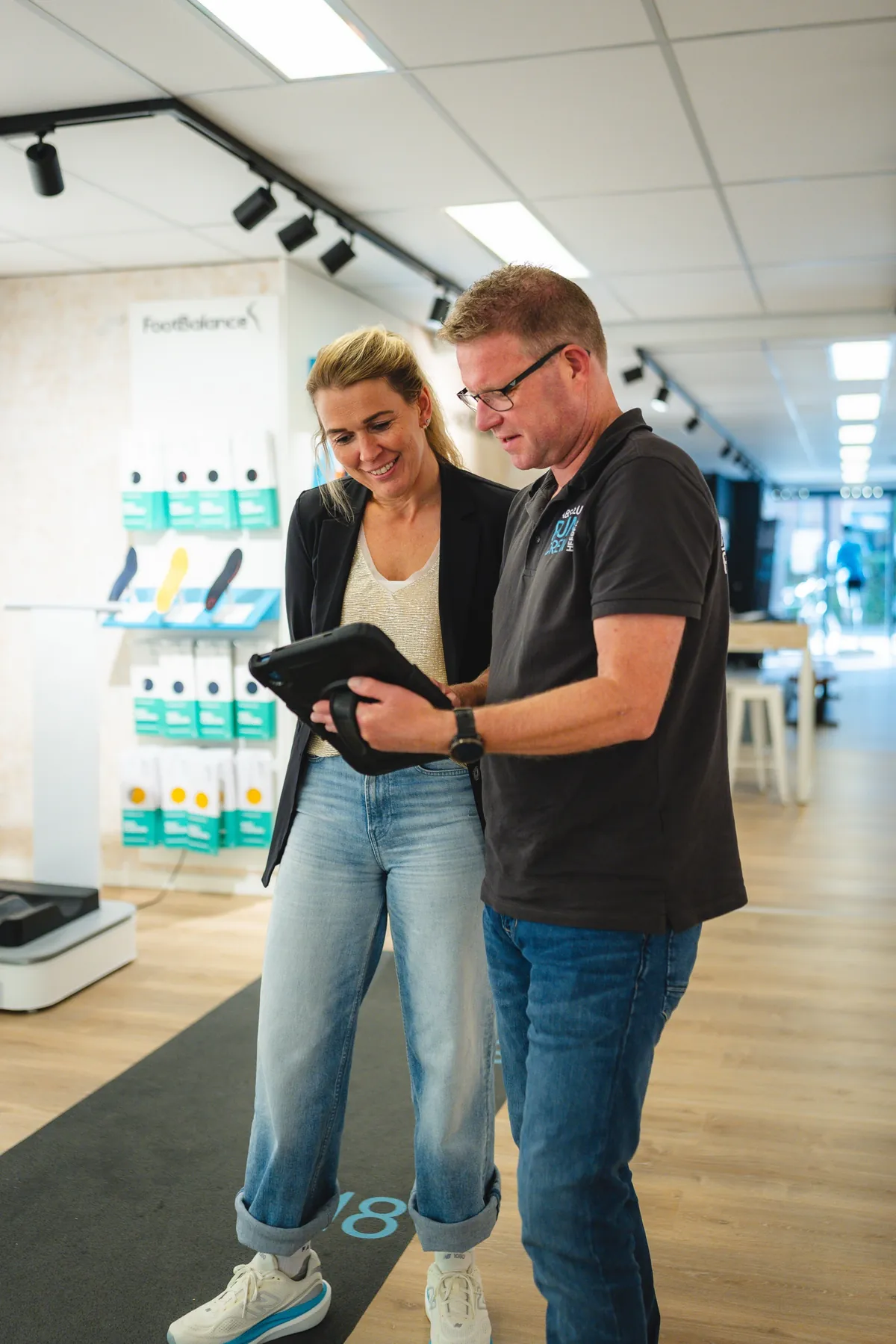 Een medewerker van Absolute Run Faber Sport neemt de beelden van de loopanalyse met een klant door op een iPad